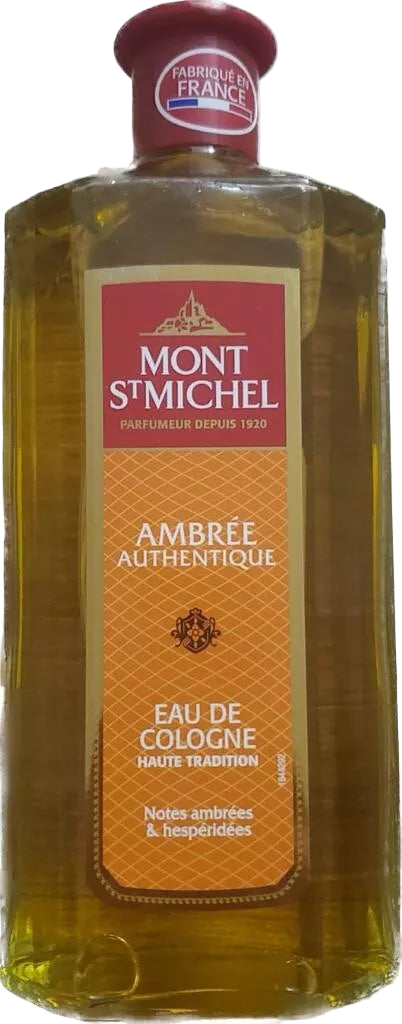 A bottle of Mont St Michel Eau de cologne Ambré Authentique with a amber colored label and a red cap.